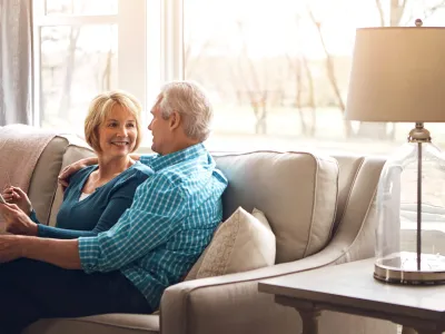 Old Couple Smiling on Couch in New Home