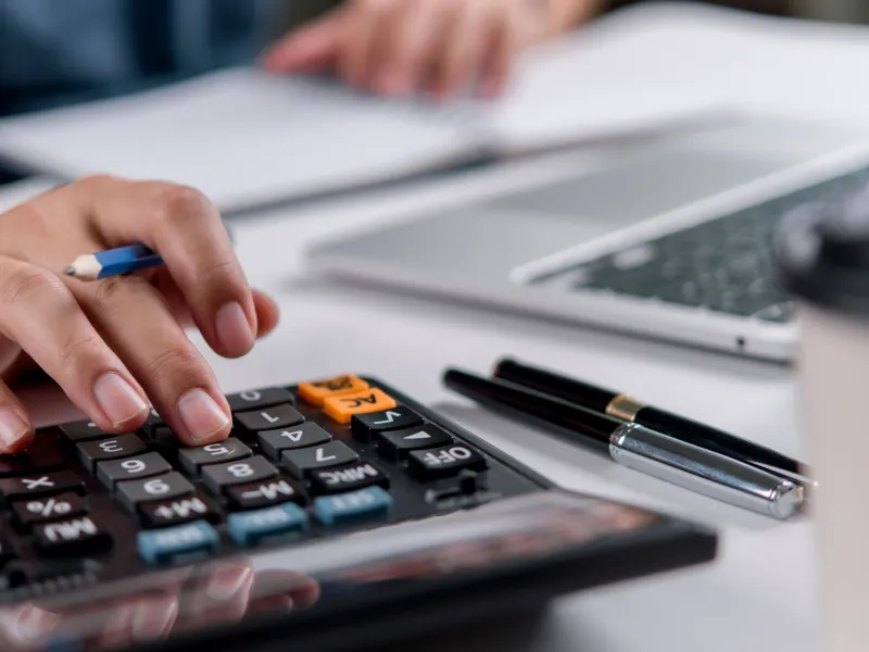 Man typing on calculator