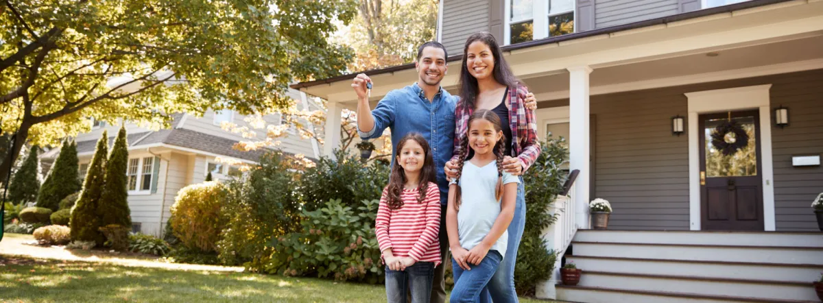 Happy family in front of a home
