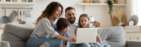 Family on couch viewing laptop