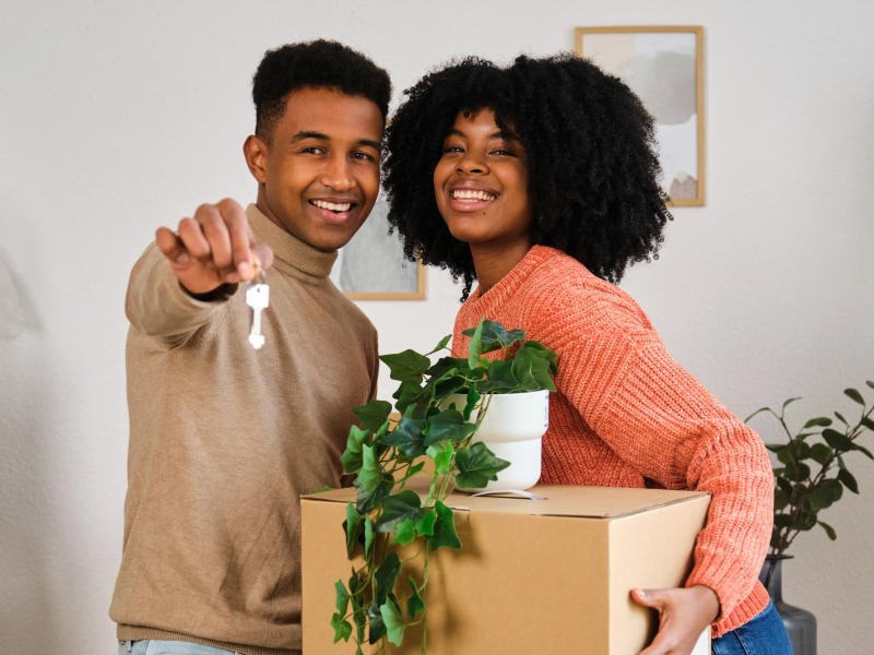 Young Hispanic Couple holding a key in their New Home