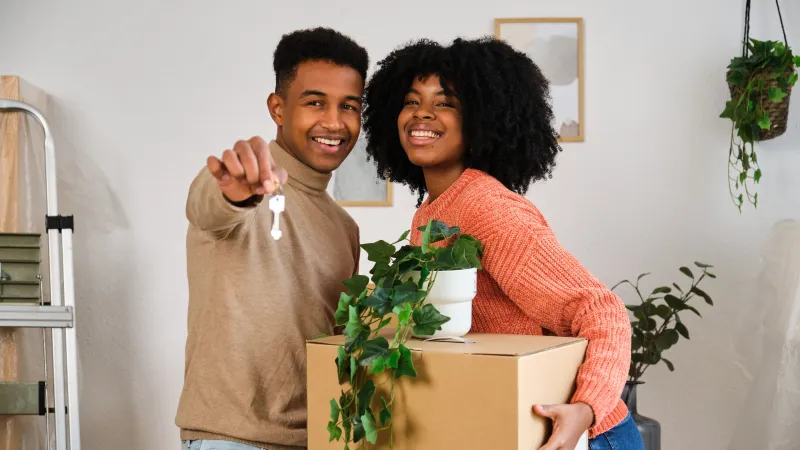 Young couple celebrating with a new home key