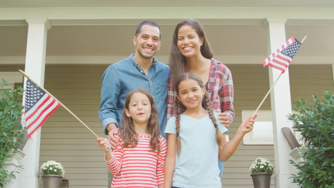 Hispanic family at home waving USA flags