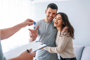 happy couple signing paperwork to receive keys to new home