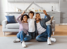 Happy young family sitting on floor of new home