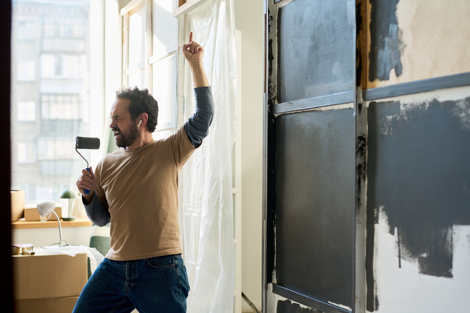 Man singing into a paint roller excited about his new home additions