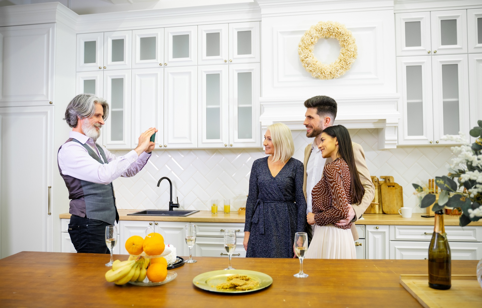 Grandfather taking a picture of his wife and daughter in their home
