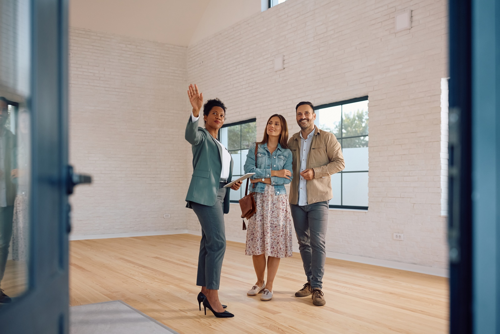 Real estate agent showing home to a new couple that just got a loan